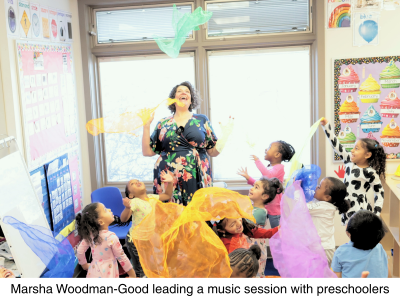 Marsha in a Head Start classroom where she and the students are singing with scarves