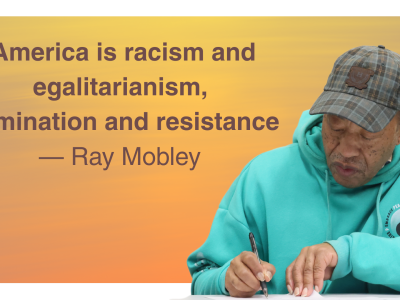 The quote America is racism and egalitarianism, Domination and resistance by and a photo cutout of Ray Mobley in teal hooding and a plaid ball cap writing at a table
